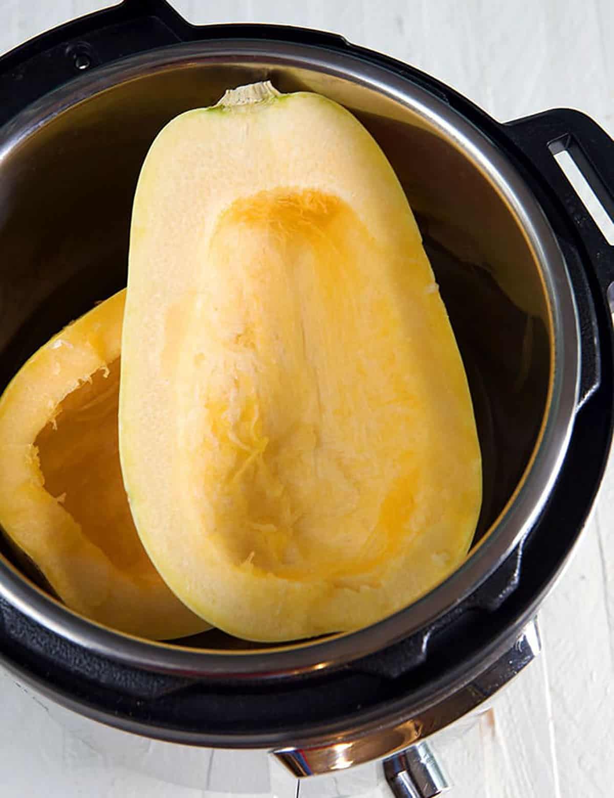 Two seedless squash halves are placed in the Instant Pot.