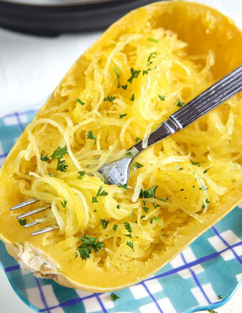 A fork is twirling a bite of spaghetti squash.