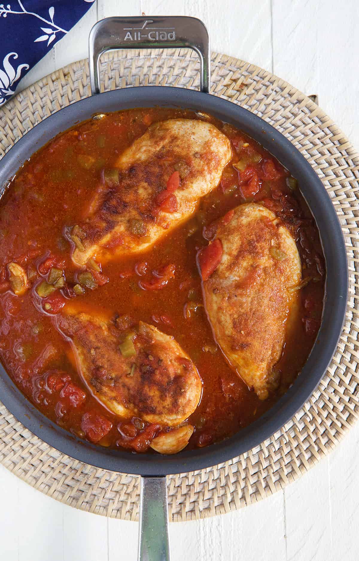 Three chicken breasts are placed in a skillet.