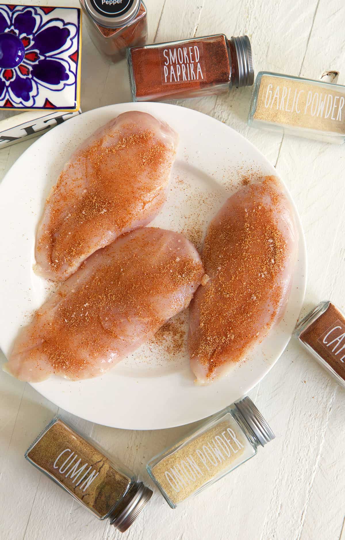 Three chicken breasts are placed on a white plate.