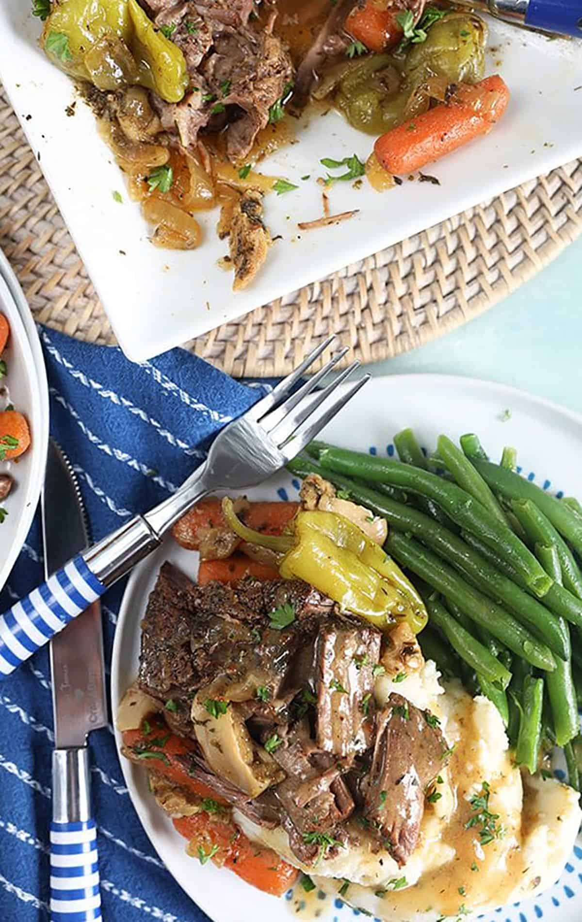 Mississippi Pot roast on mashed potatoes with a blue and white striped fork.