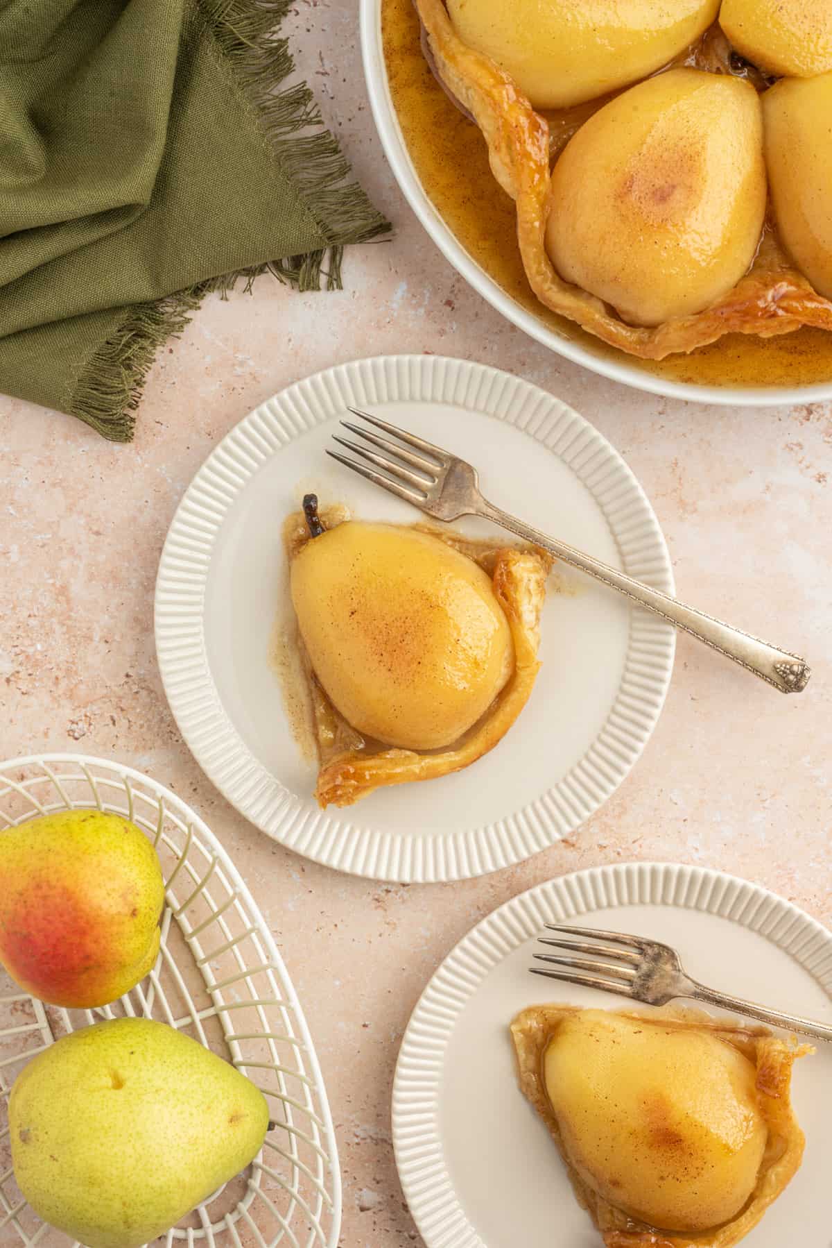 Pear Tarte Tatin slice on a white plate with a fork.