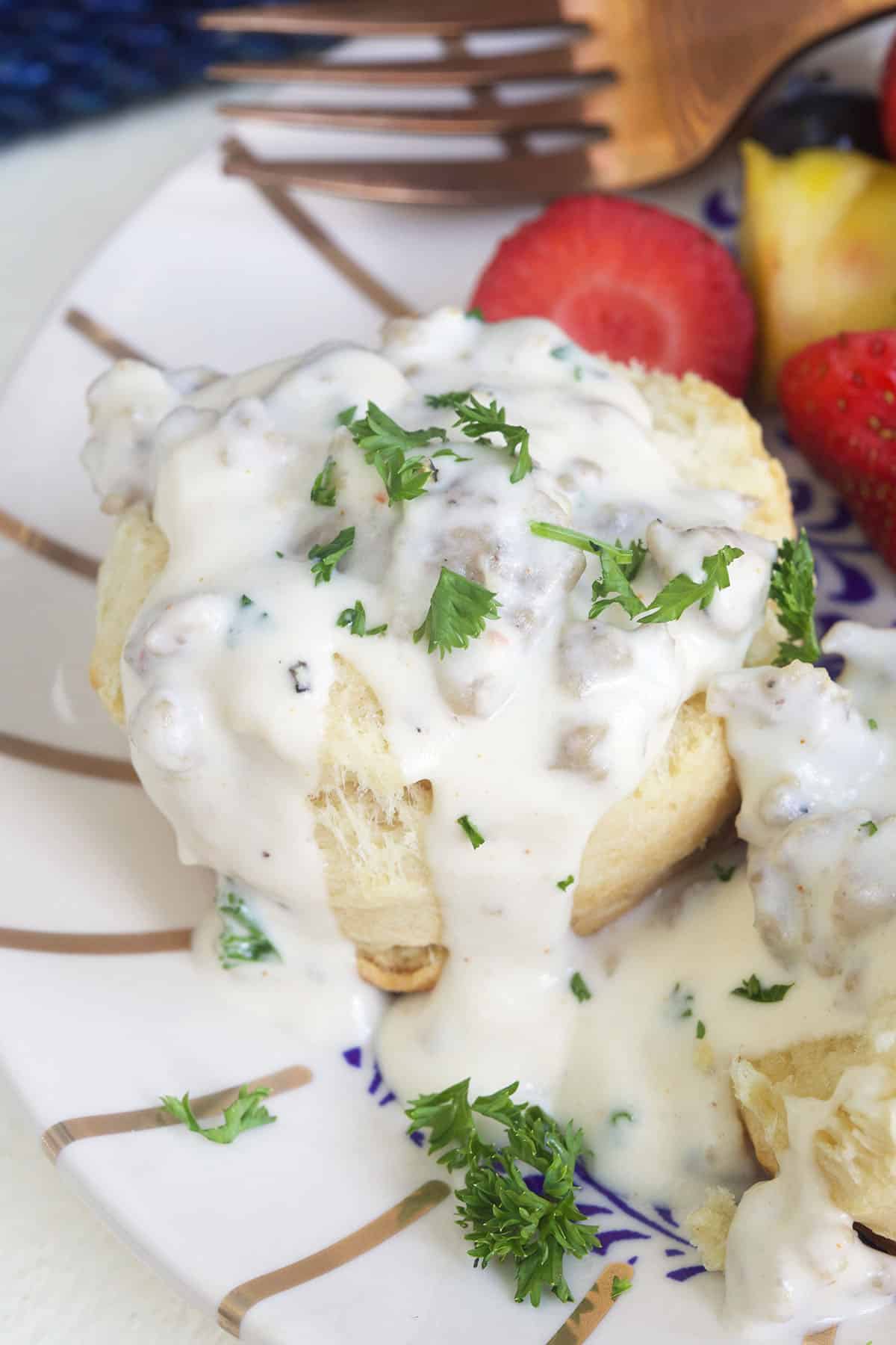 Sausage gravy is placed on a cooked biscuit.