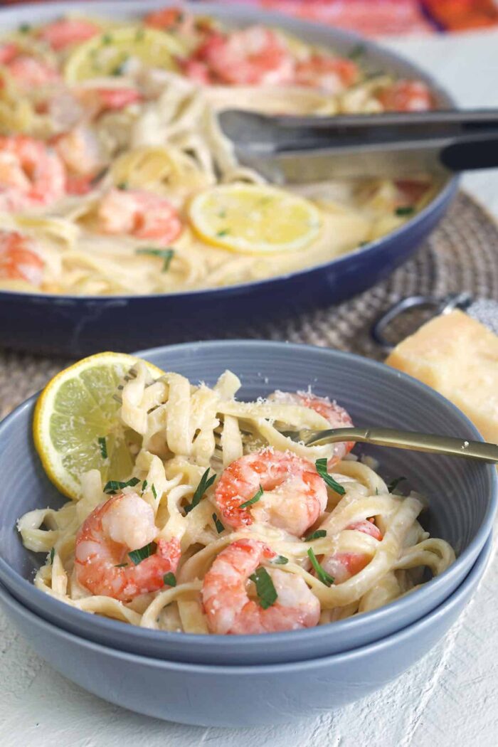 A bowl is filled with pasta and shrimp.