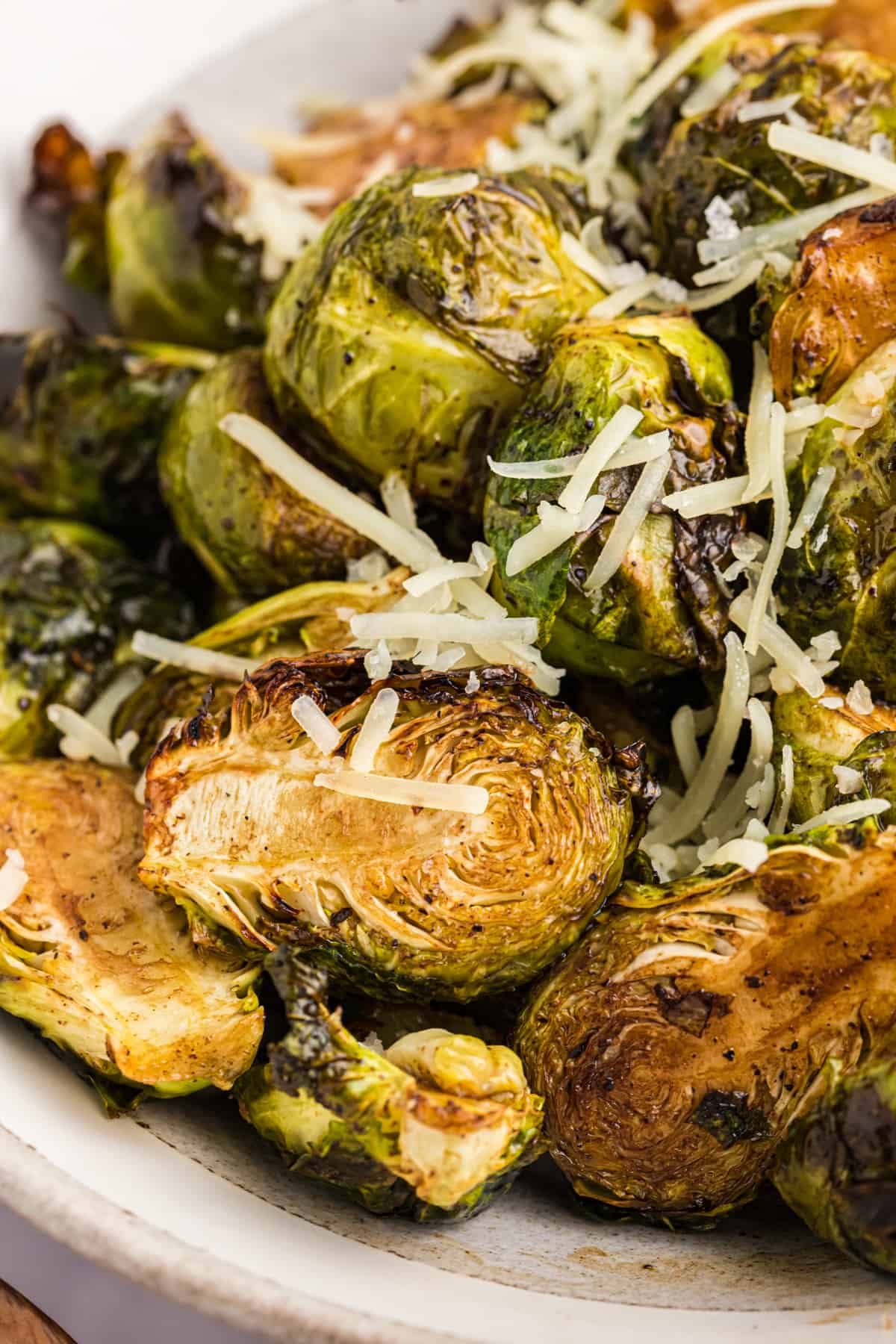 Shredded parmesan is sprinkled across the top of air fried brussels sprouts.