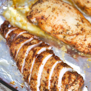 Sliced baked chicken breast on a baking sheet with foil.