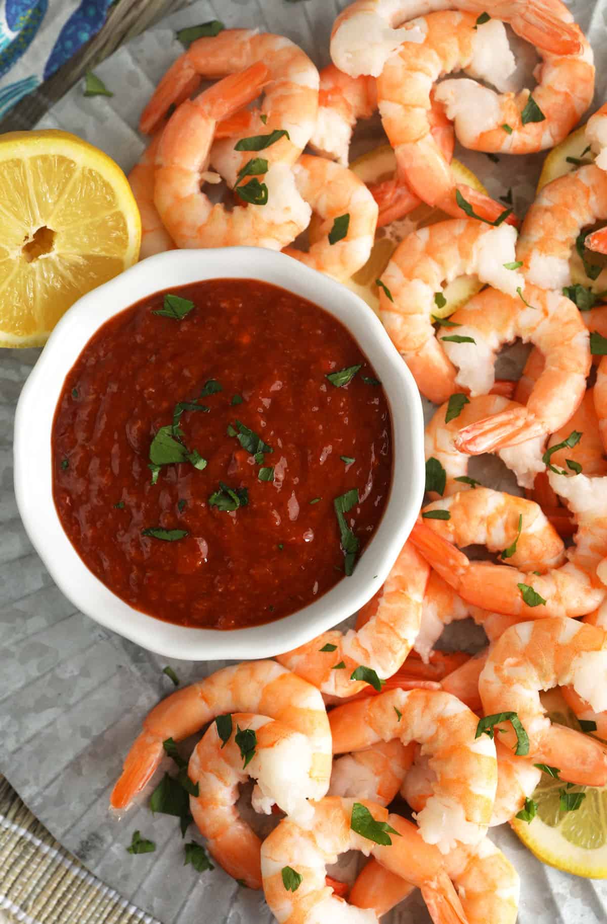 Overhead view of cocktail sauce in bowl on platter of shrimp