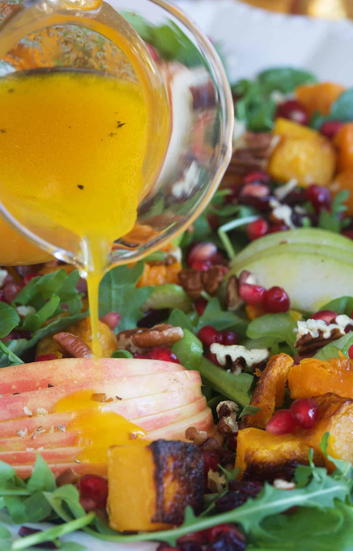 Vinaigrette is being drizzled all over a salad.