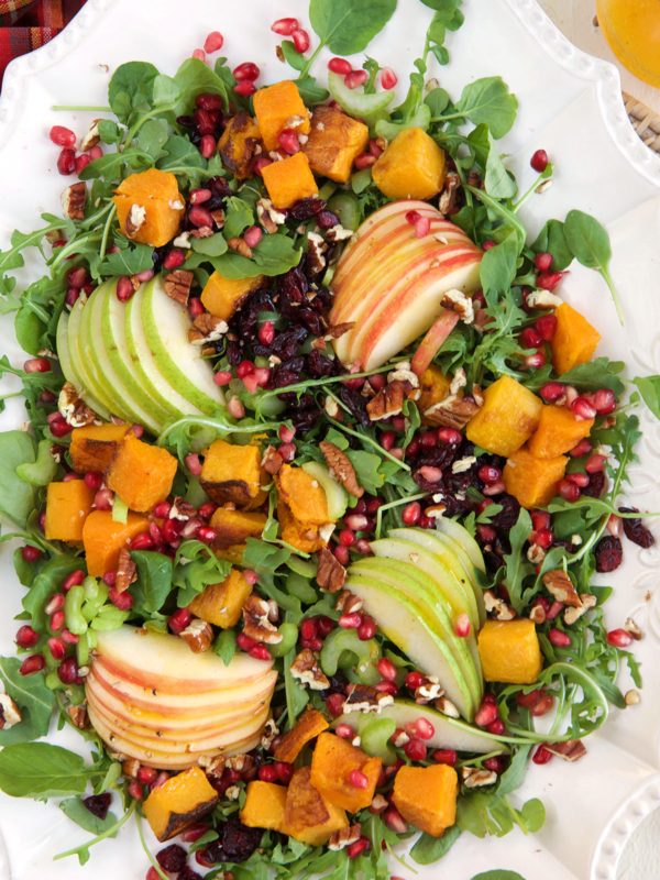 A large serving platter is topped with a vibrant salad.