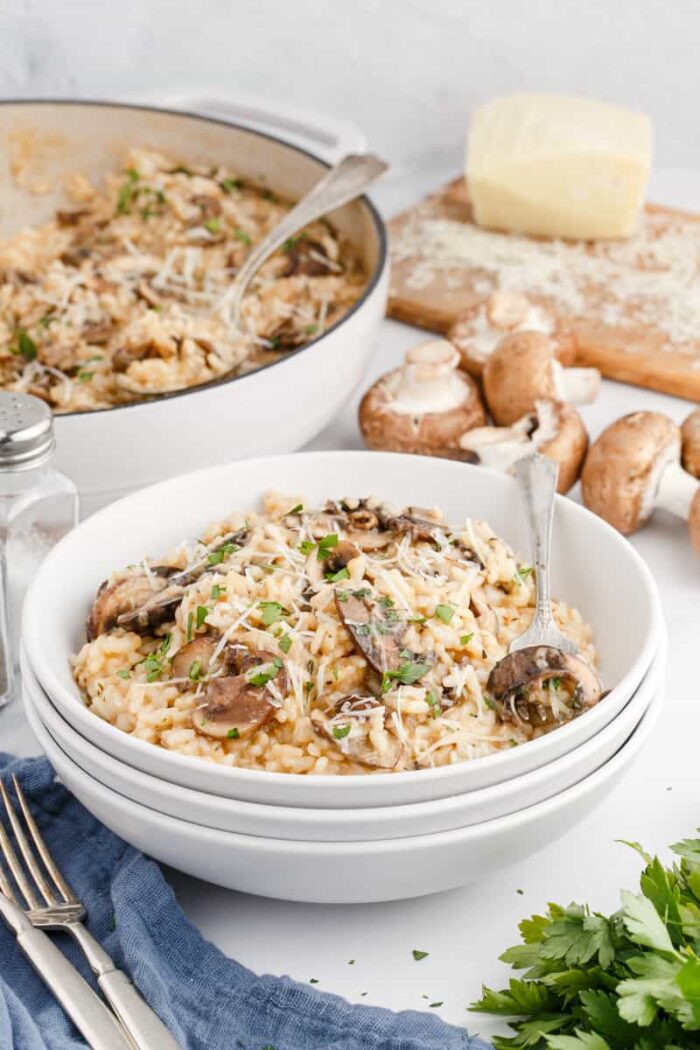 A serving of mushroom risotto is placed in a white bowl.