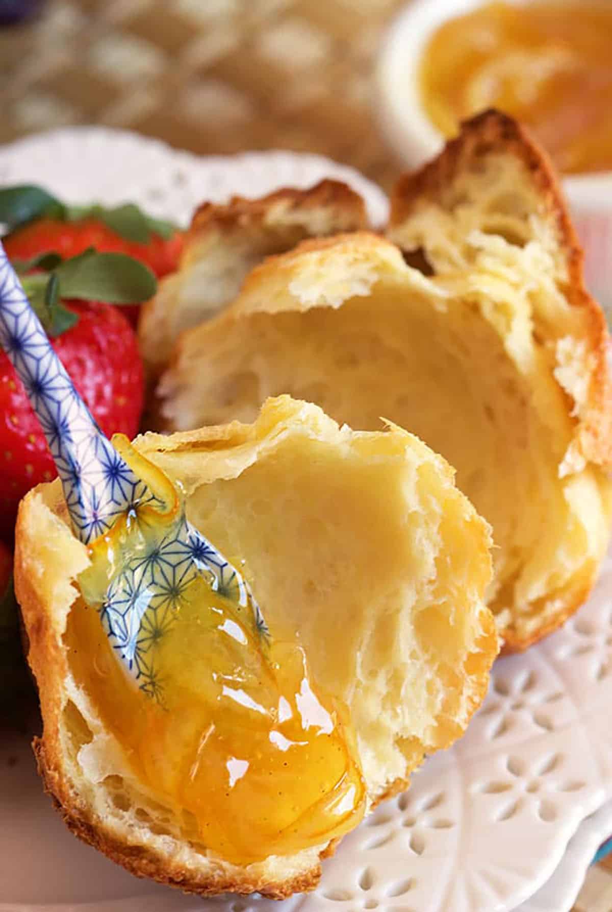 Popover broken in half with a blue and white spoon with jam