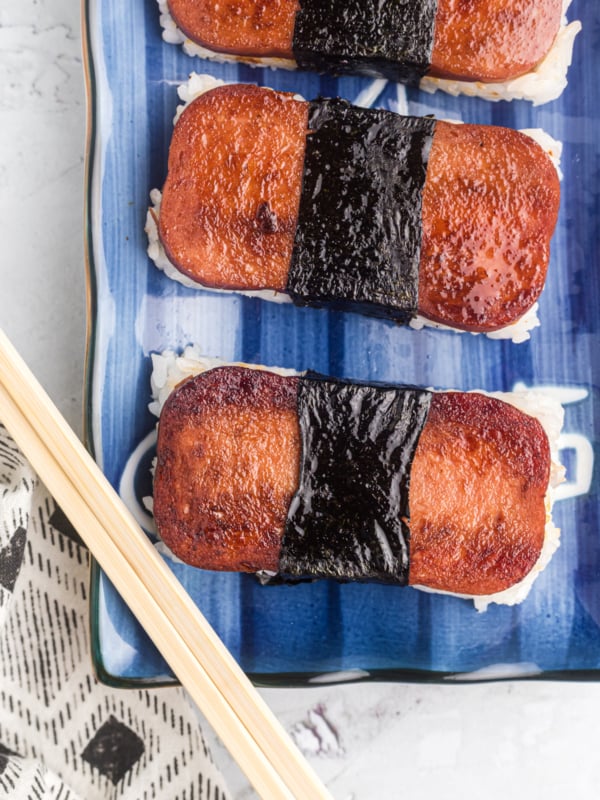 Spam musubi is placed on a blue and white plate.