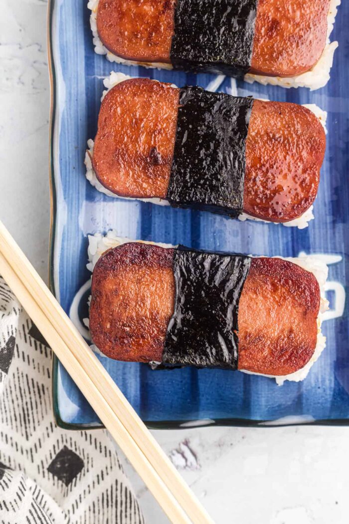 Spam musubi is placed on a blue and white plate.