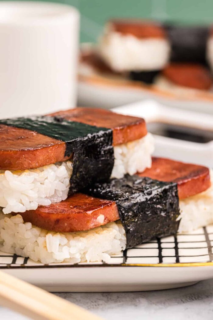 Two pieces of musubi are placed on a serving platter.