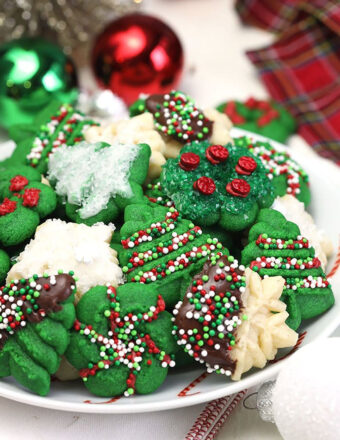 Pile of spritz cookies on a white plate.