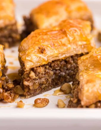 Several pieces of baklava are placed on a white plate.
