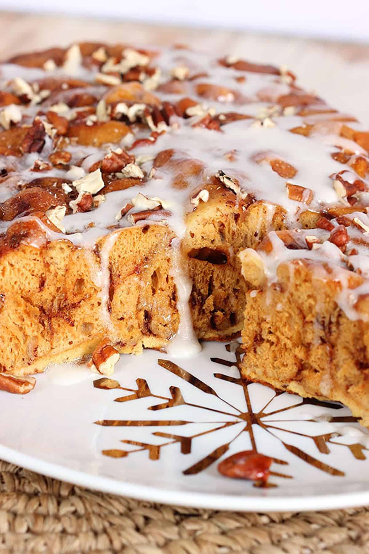 cinnamon roll casserole on a white plate with a gold snowflake on it.
