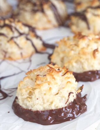 Some macaroons have been drizzled and others have been dunked in chocolate.