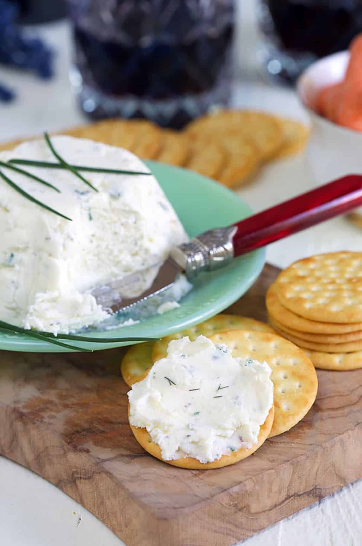 White creamy Boursin cheese is spread on a cracker.