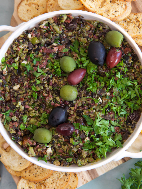 A white bowl is filled with olive tapenade.
