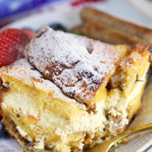 Cheesecake stuffed panettone French toast casserole on a white plate.