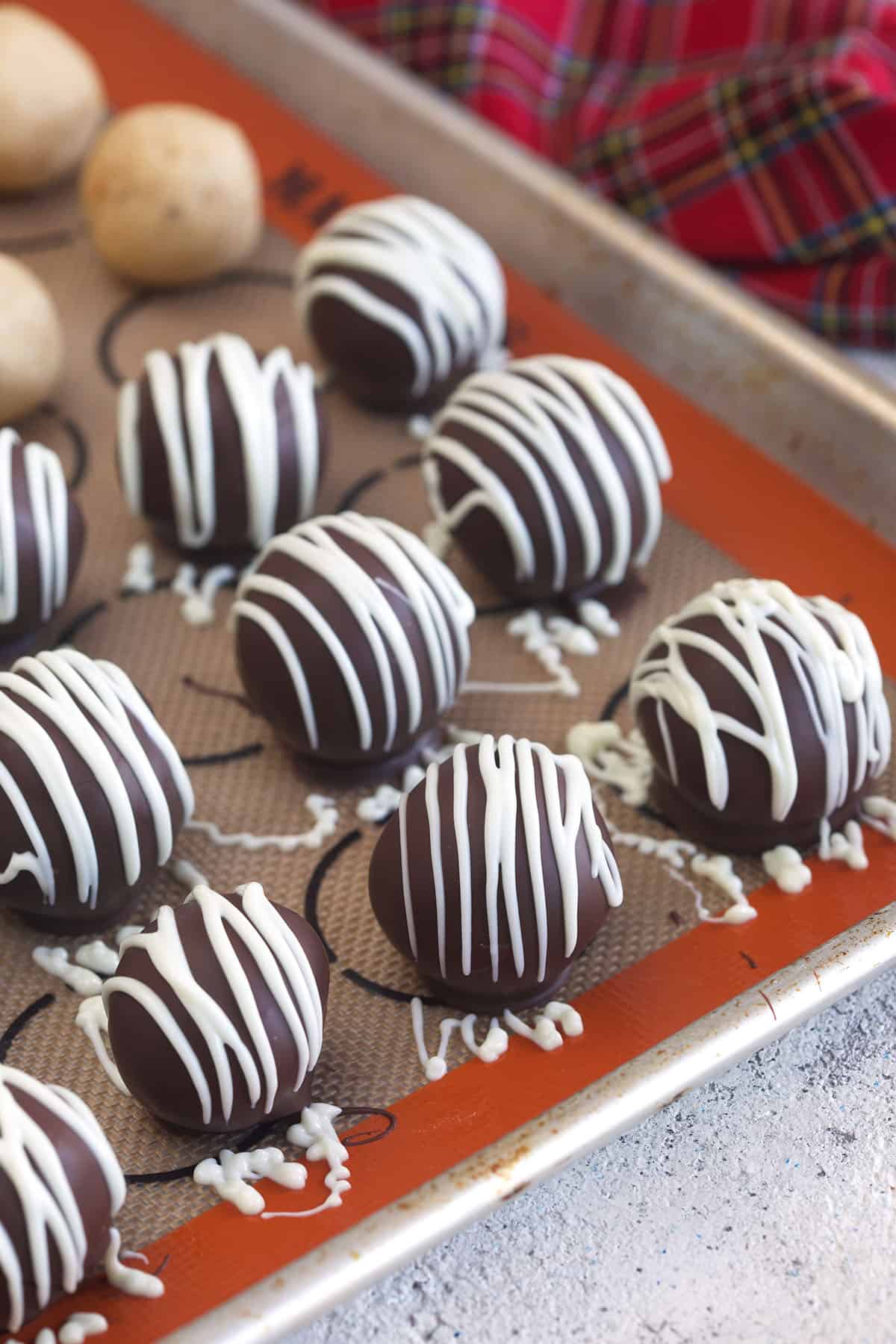 Peanut butter balls are placed on a baking sheet.