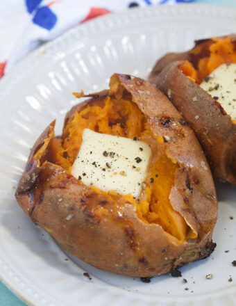 A square of butter is placed in the inside of a cooked sweet potato.