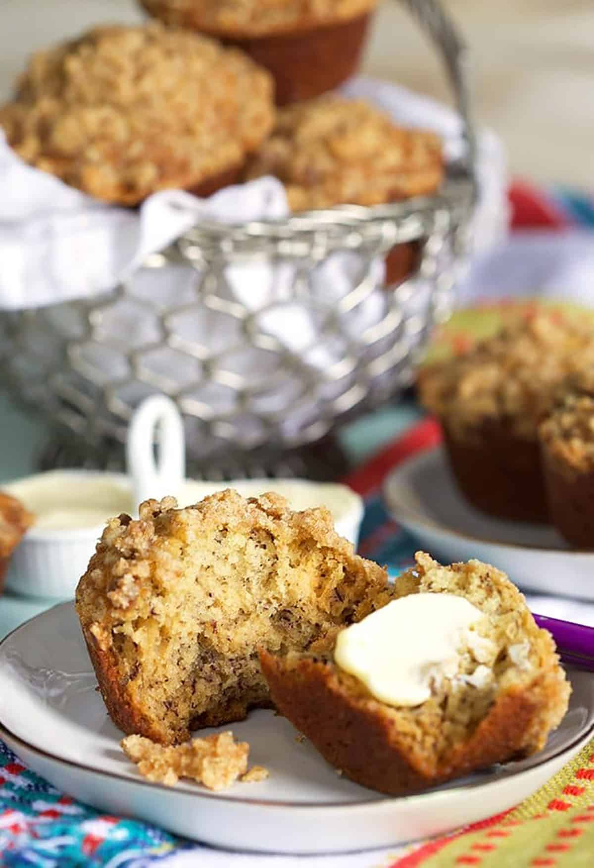 Banana Bread muffin on a white plate with a pat of butter.