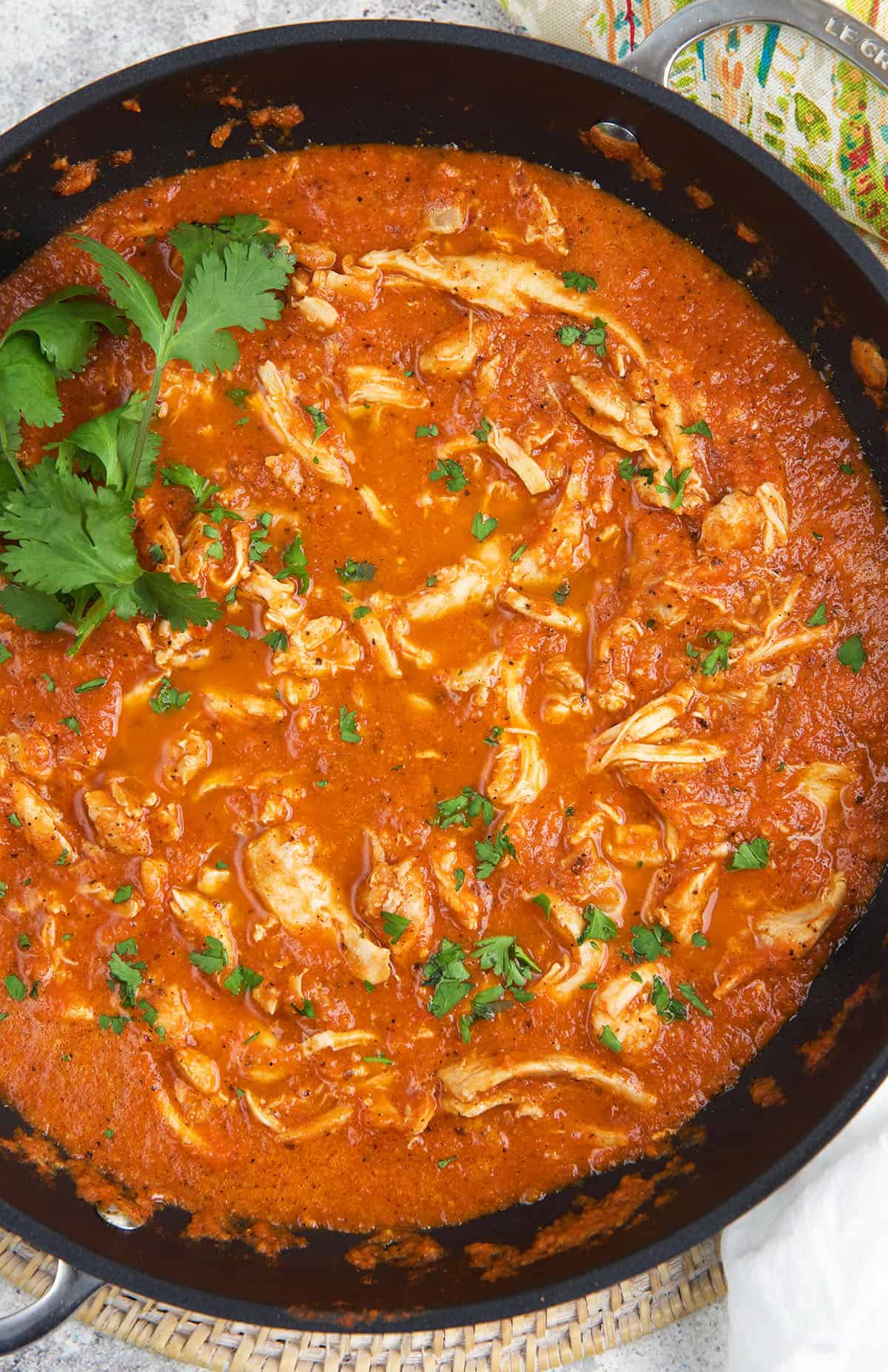 A skillet is filled with cooked chicken tinga.