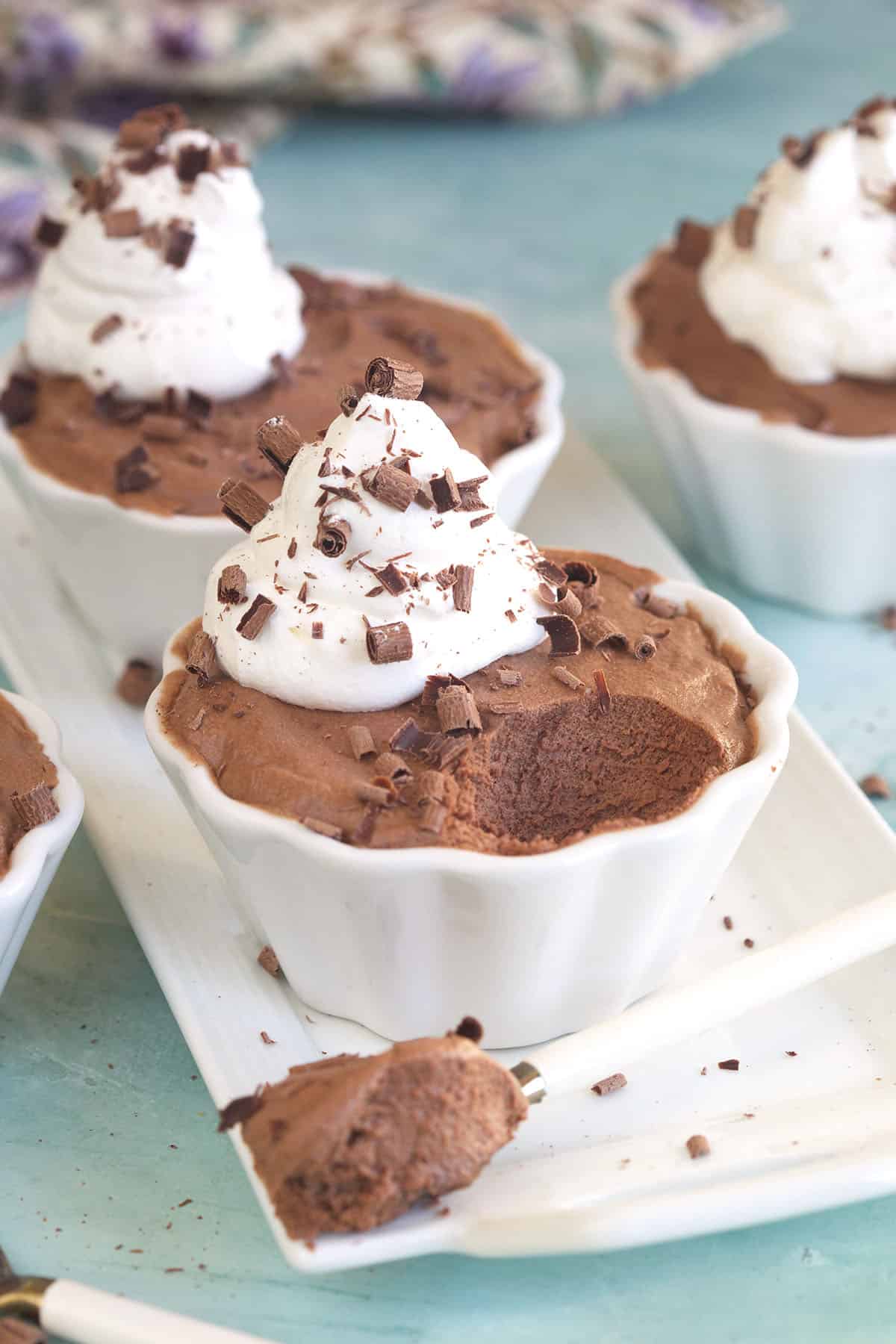 chocolate mousse in a white ramekin with a dollop of whipped cream on top