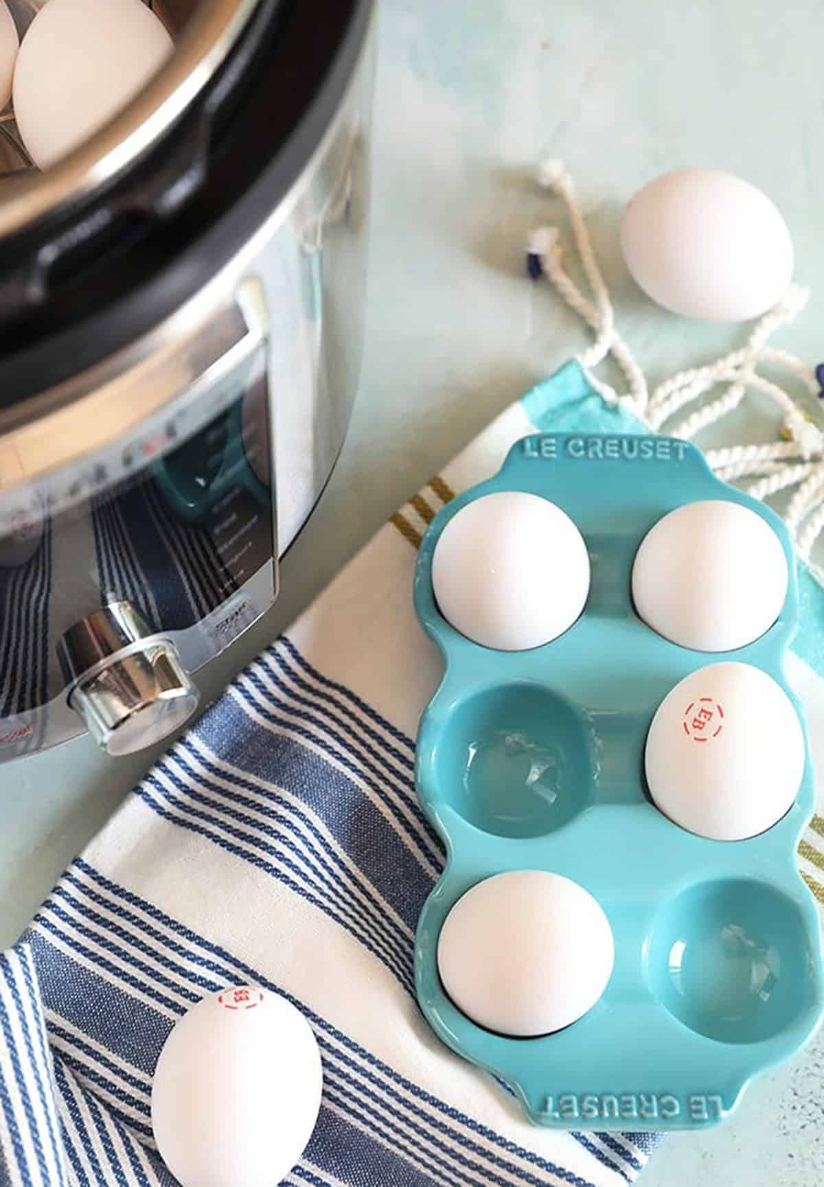 Eggs in a blue egg crate with an Instant Pot on the side.