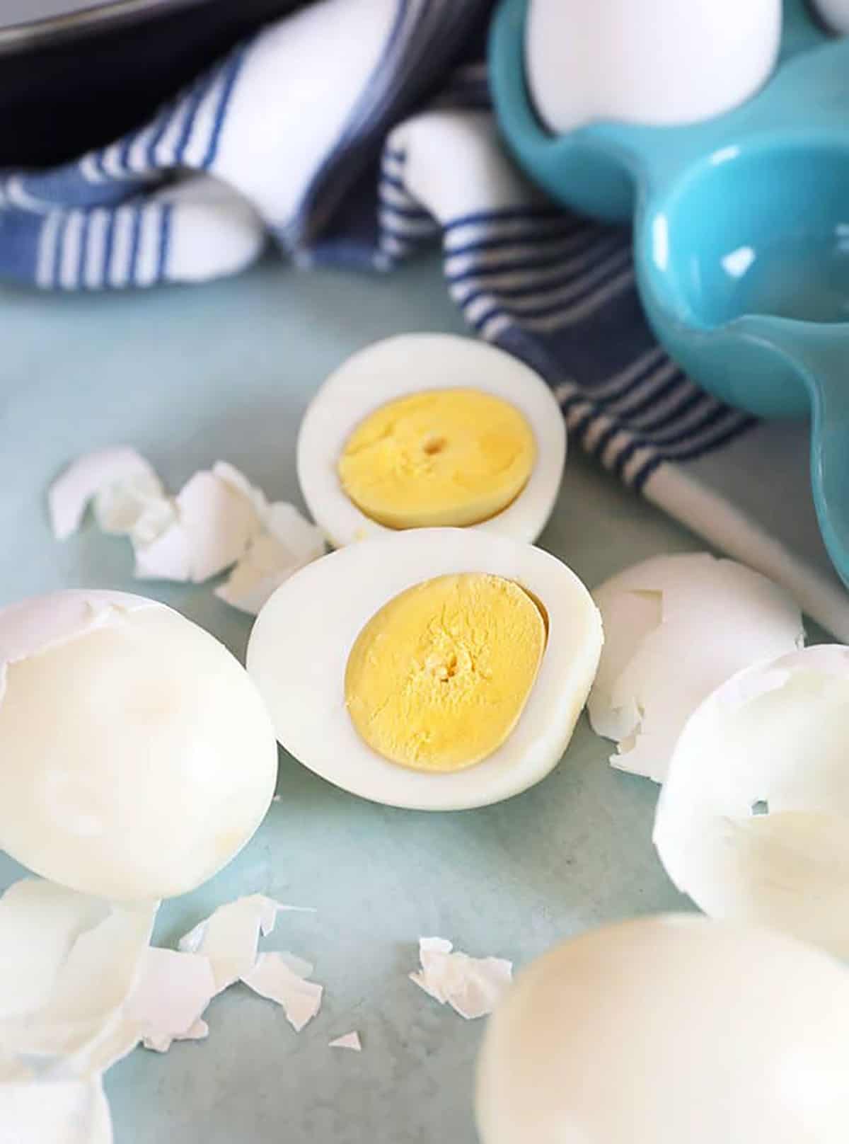 Hard boiled eggs cut in half with shells around.