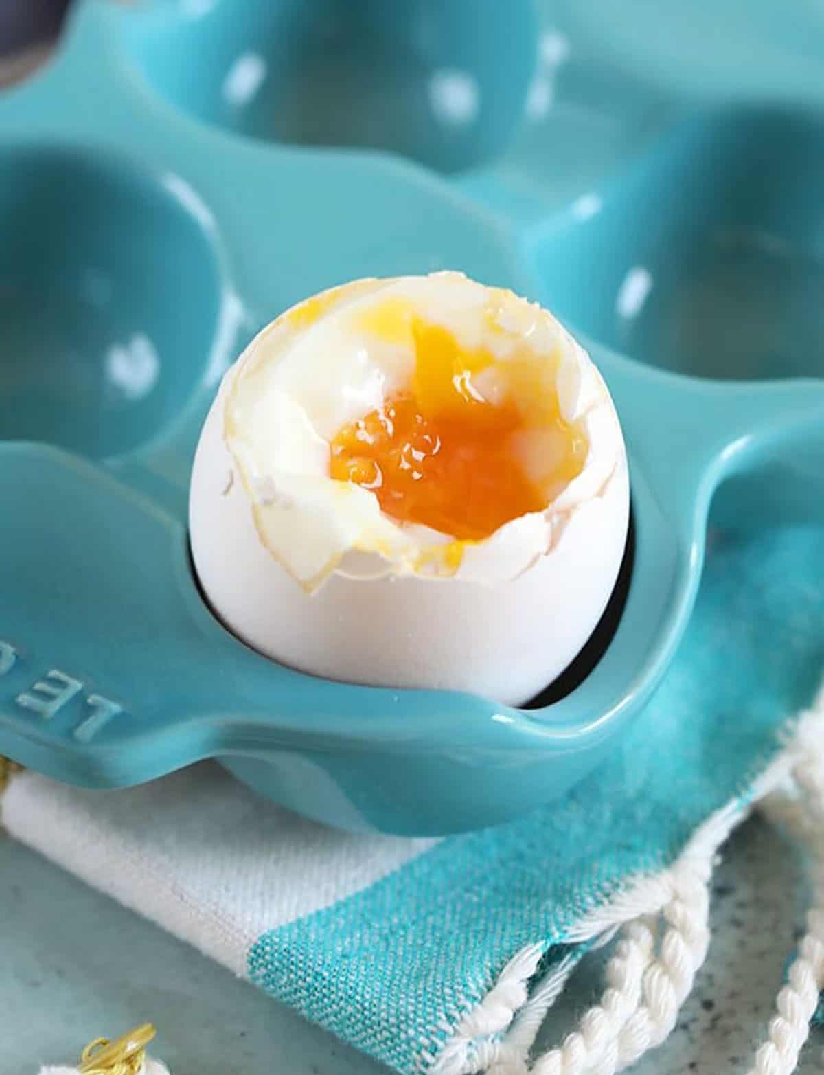 Soft Boiled egg with the top snipped off in an egg crate.