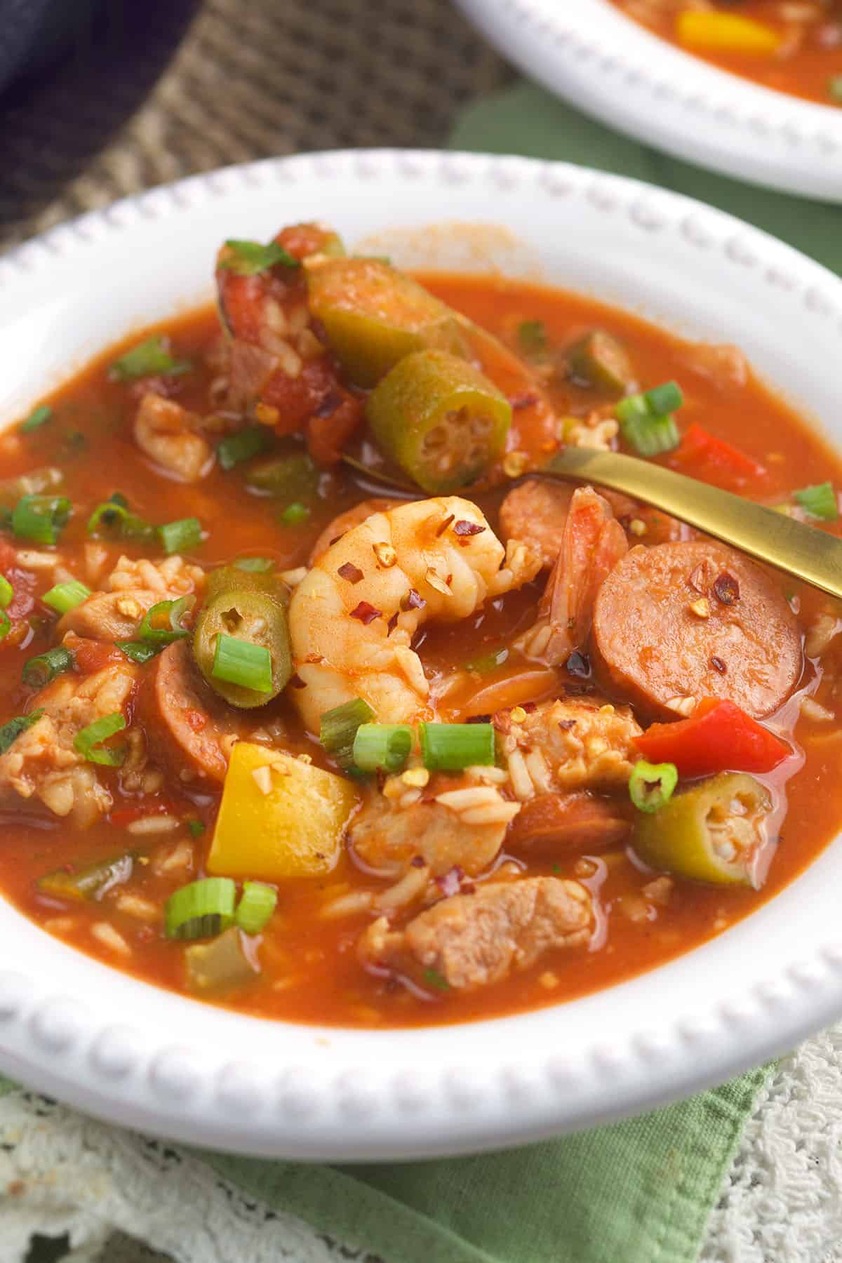 A white bowl is filled with jambalaya. 