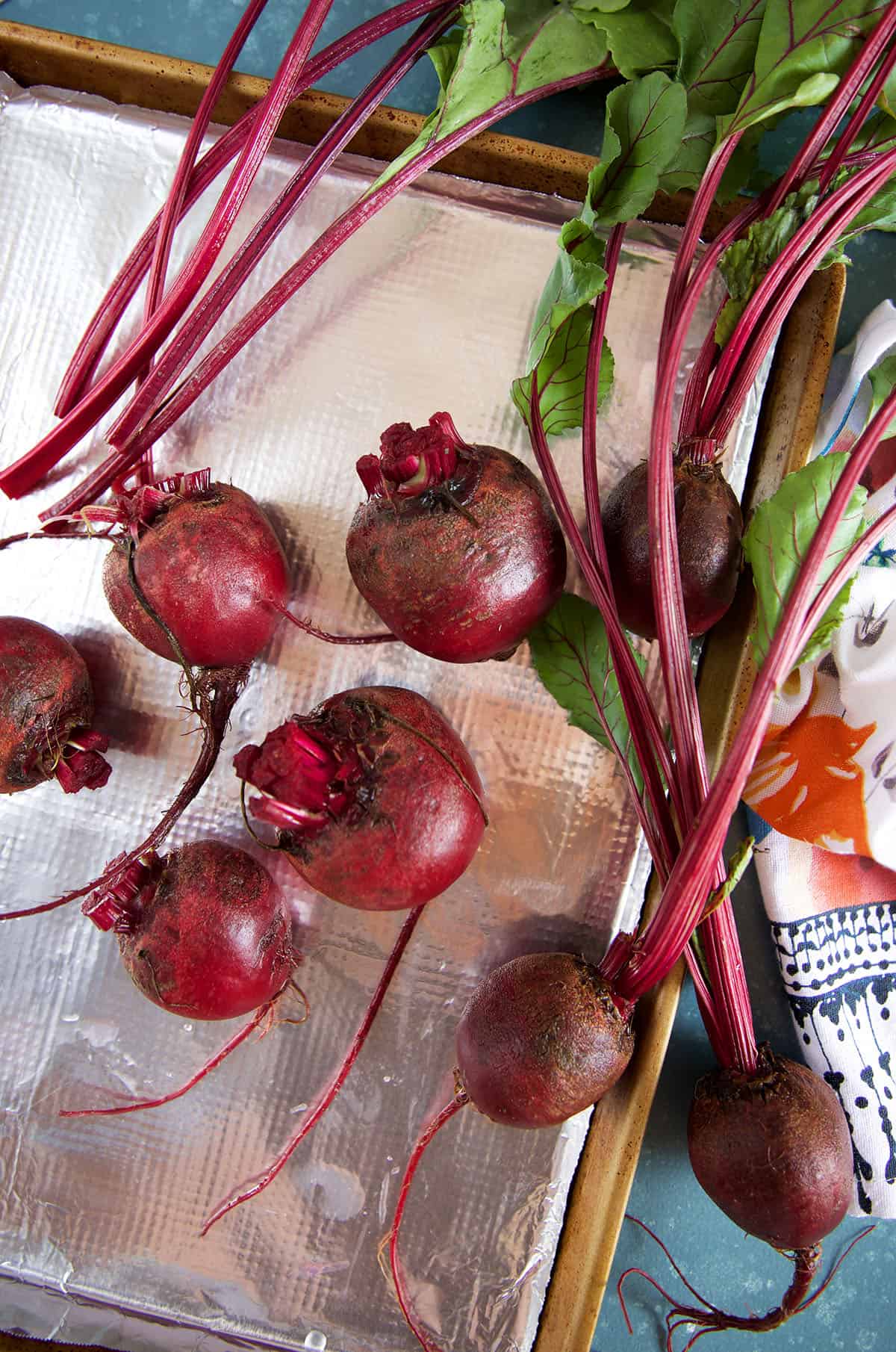 Whole beets are placed on a baking sheet.