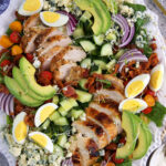 A cobb salad is plated on a large white serving plate.