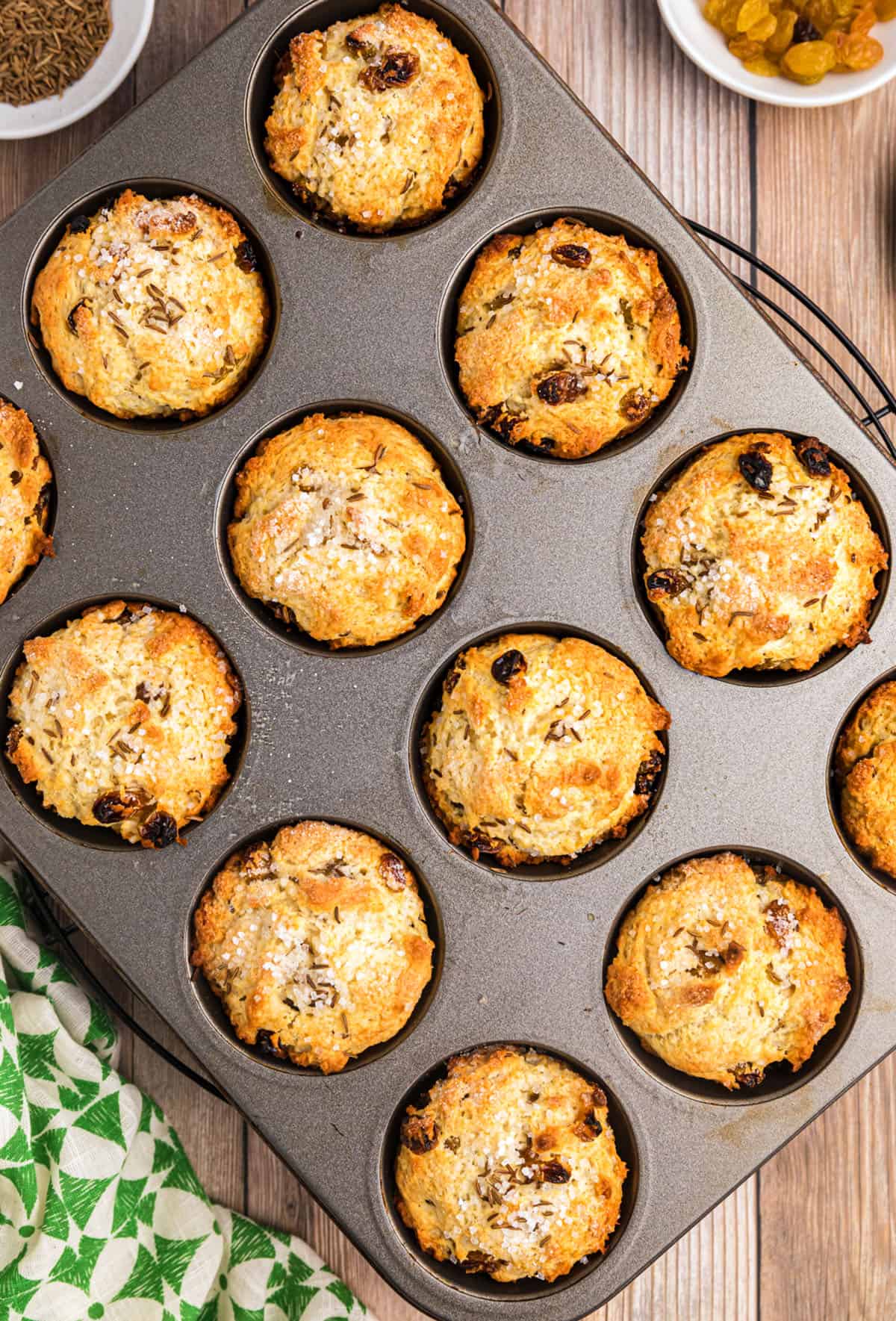 Irish Soda Bread Muffins in a muffin pan with a green and white napkin to the side.