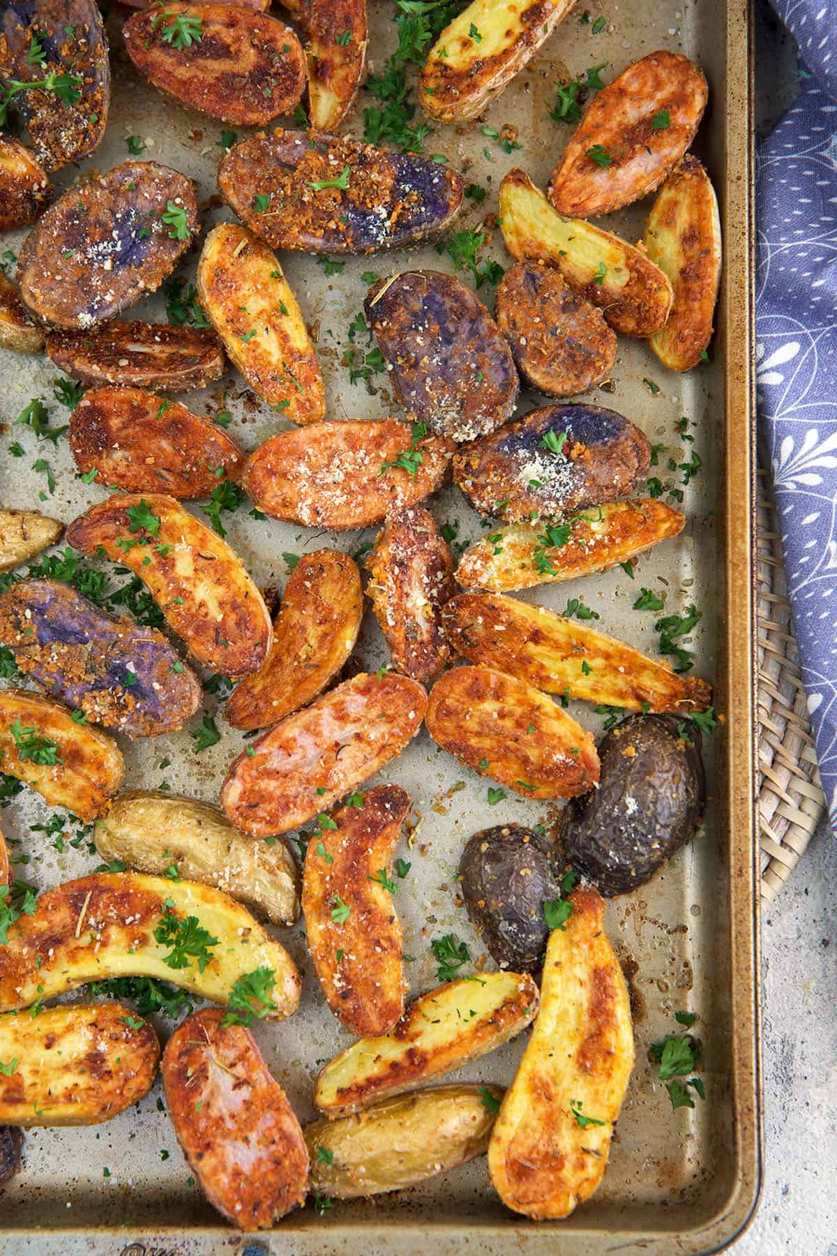 Roasted fingerling potatoes are spread out across a baking sheet.