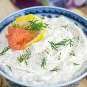A blue and white bowl is filled with smoked salmon dip.