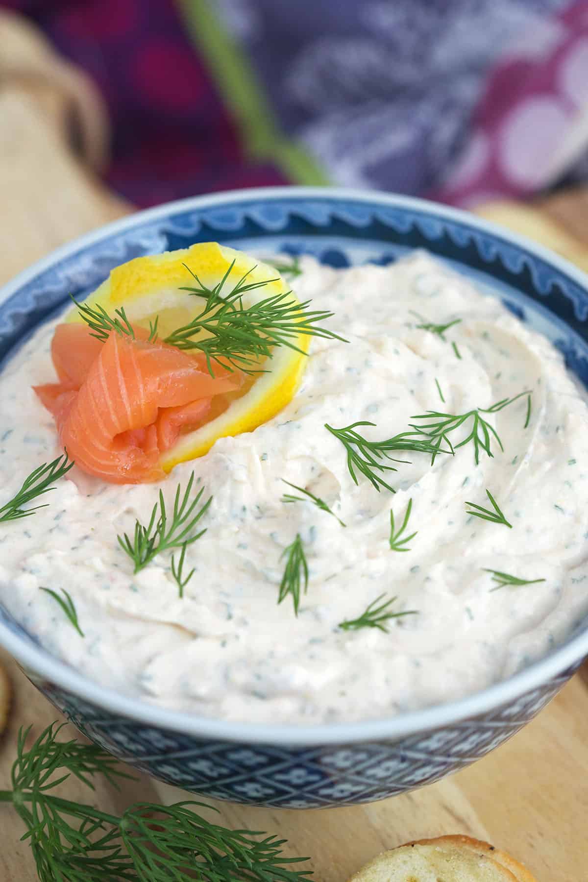A blue and white bowl is filled with smoked salmon dip.