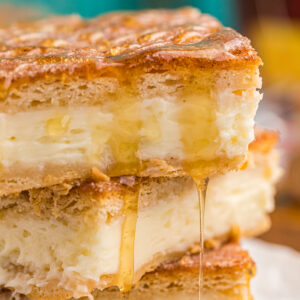 Sopapilla cheesecake bars are drizzled with honey.