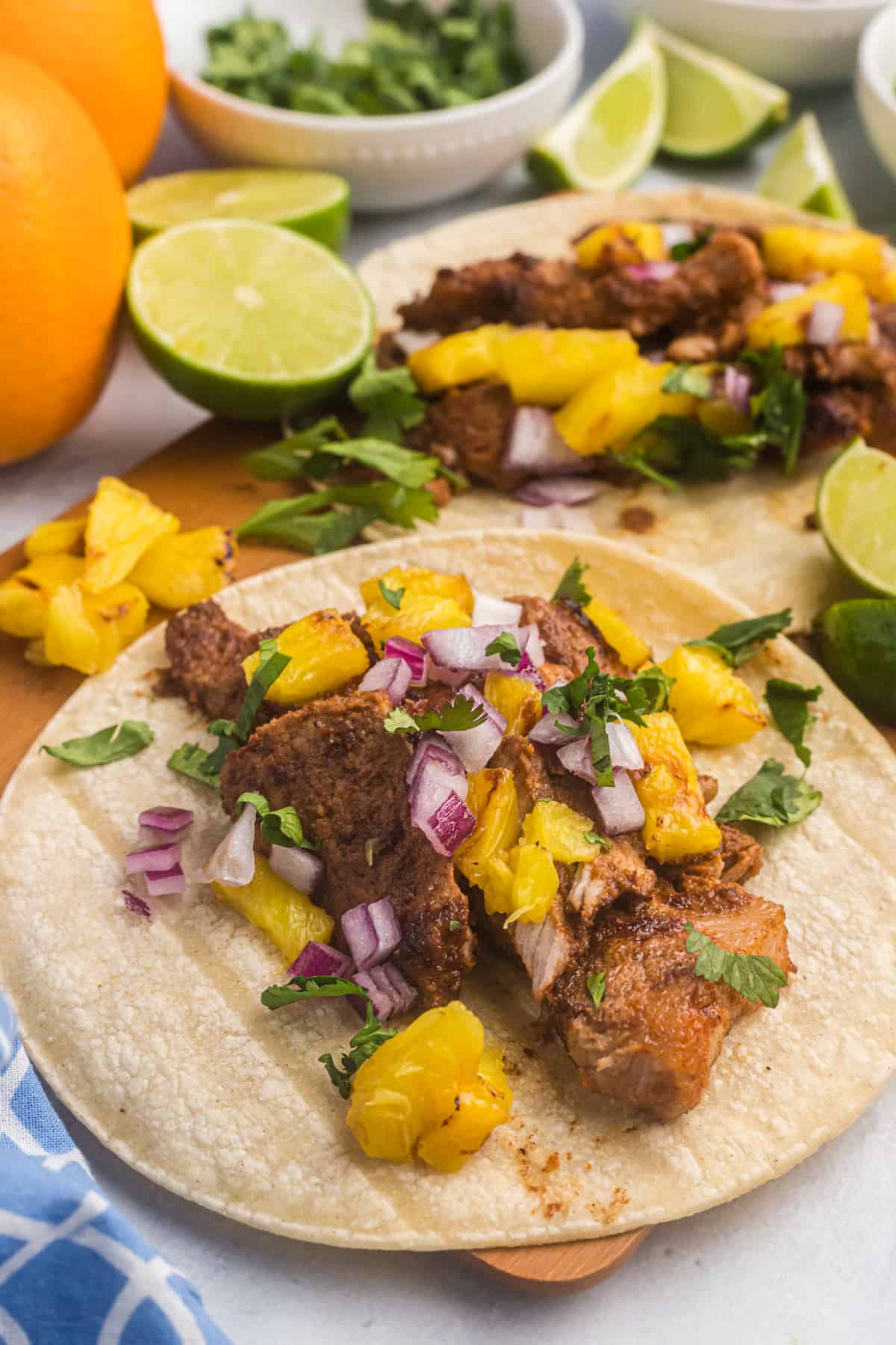 A corn tortilla is filled with cooked meat and pineapple salsa.