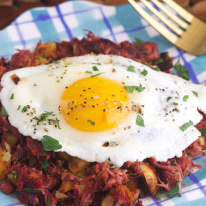 An egg is placed on top of a serving of corned beef hash.