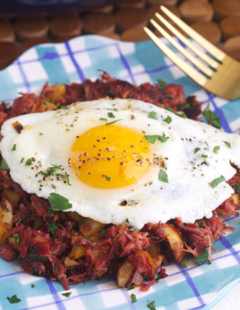 An egg is placed on top of a serving of corned beef hash.