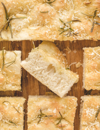 Slices of focaccia are placed on a wooden cutting board.