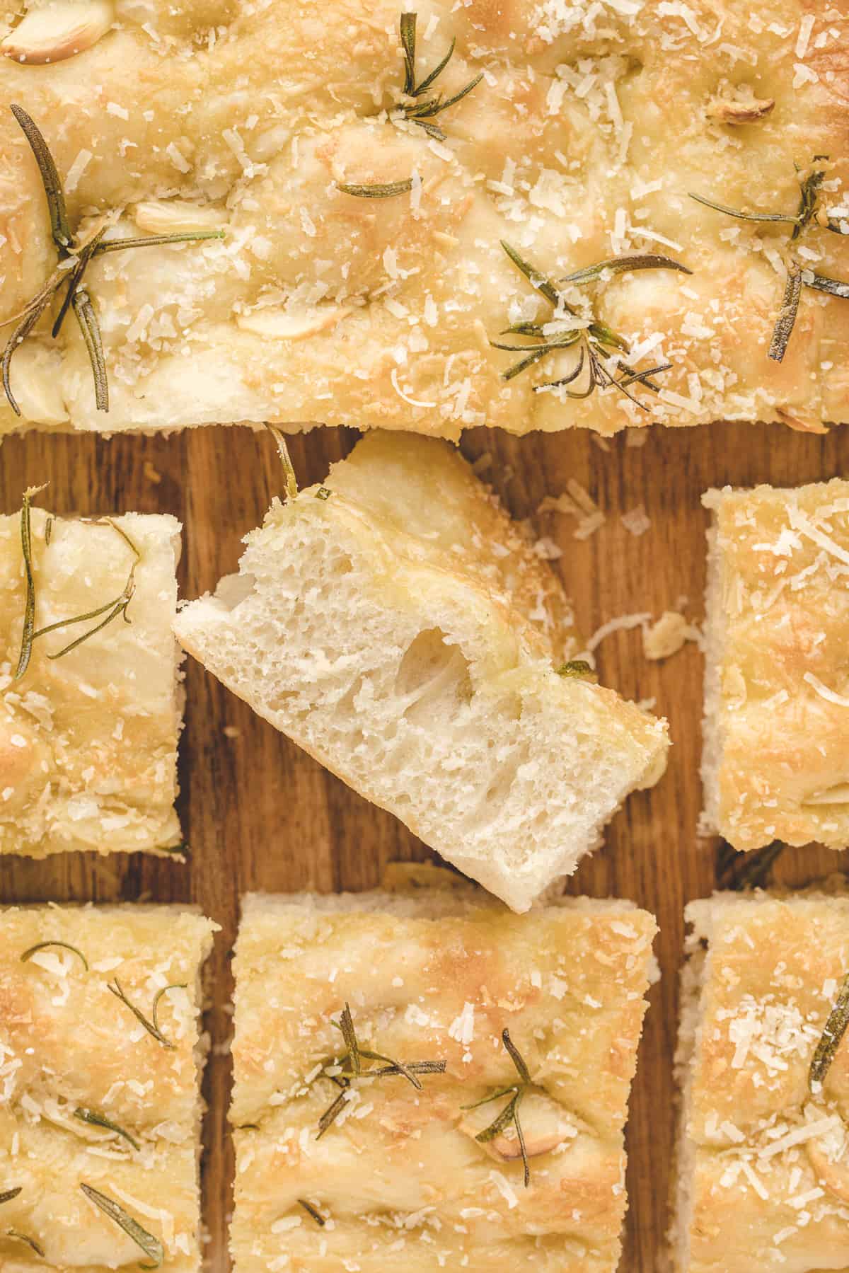 Slices of focaccia are placed on a wooden cutting board.