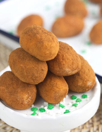 Irish potatoes are stacked in a pile on a white serving plate.