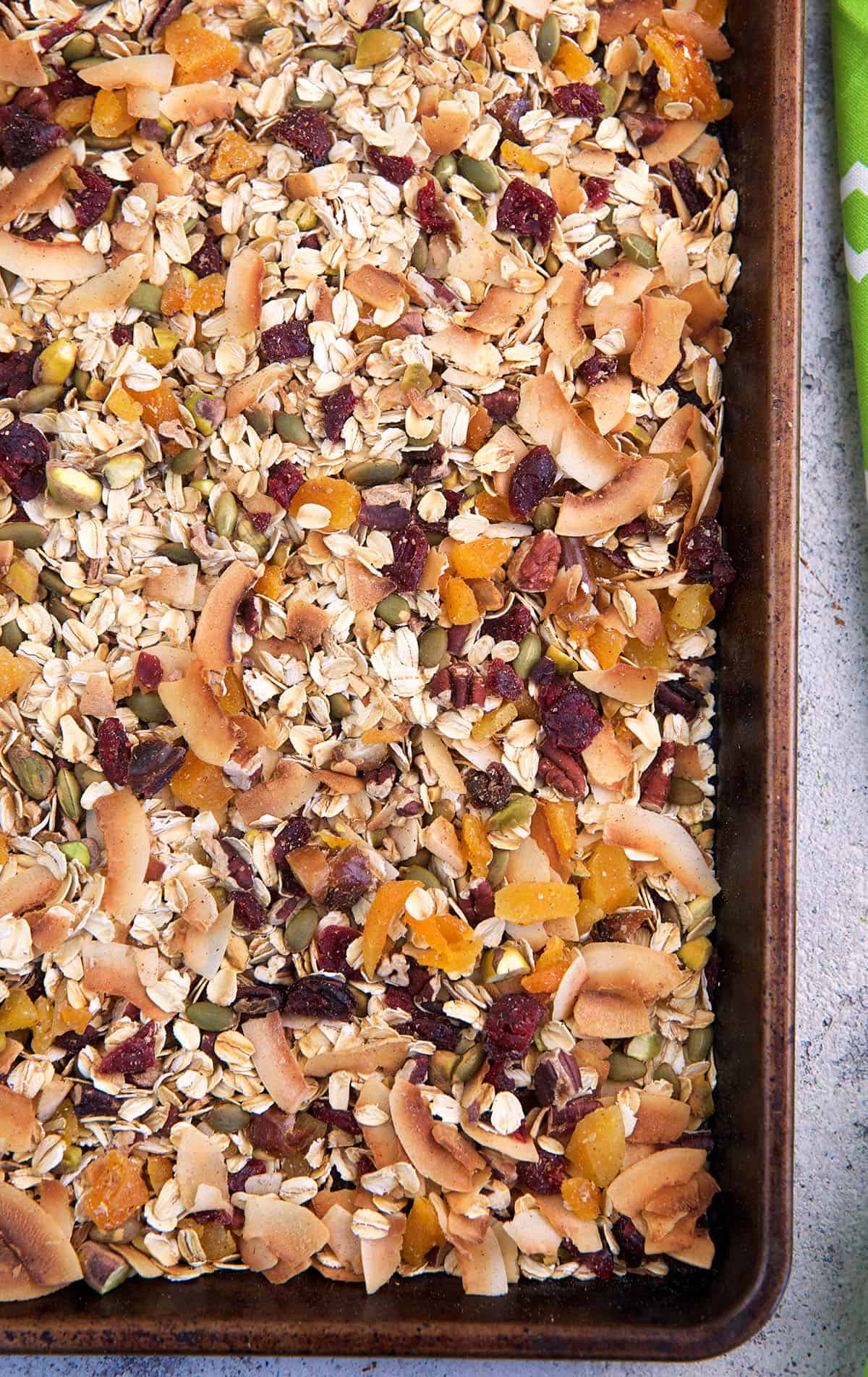 Muesli is spread out on a baking sheet.