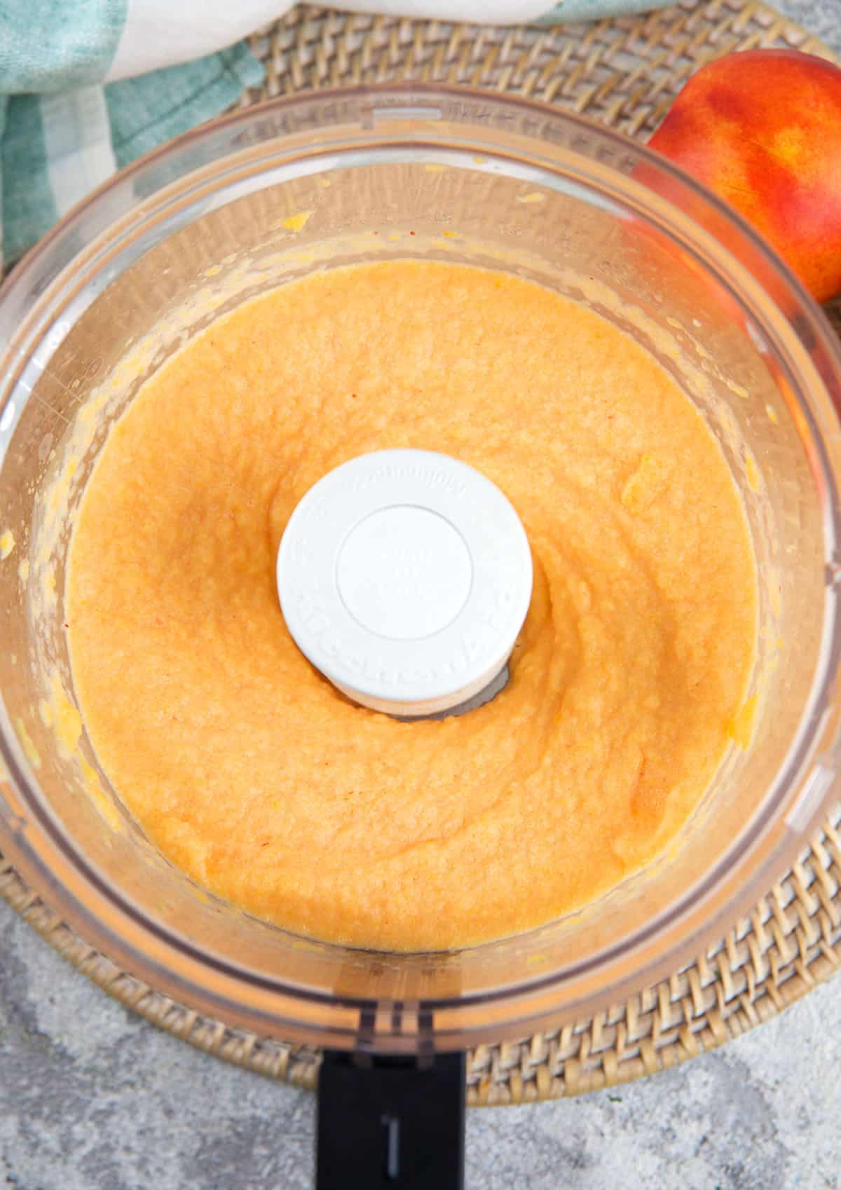 Peach puree is totally smooth in the bowl of a food processor.