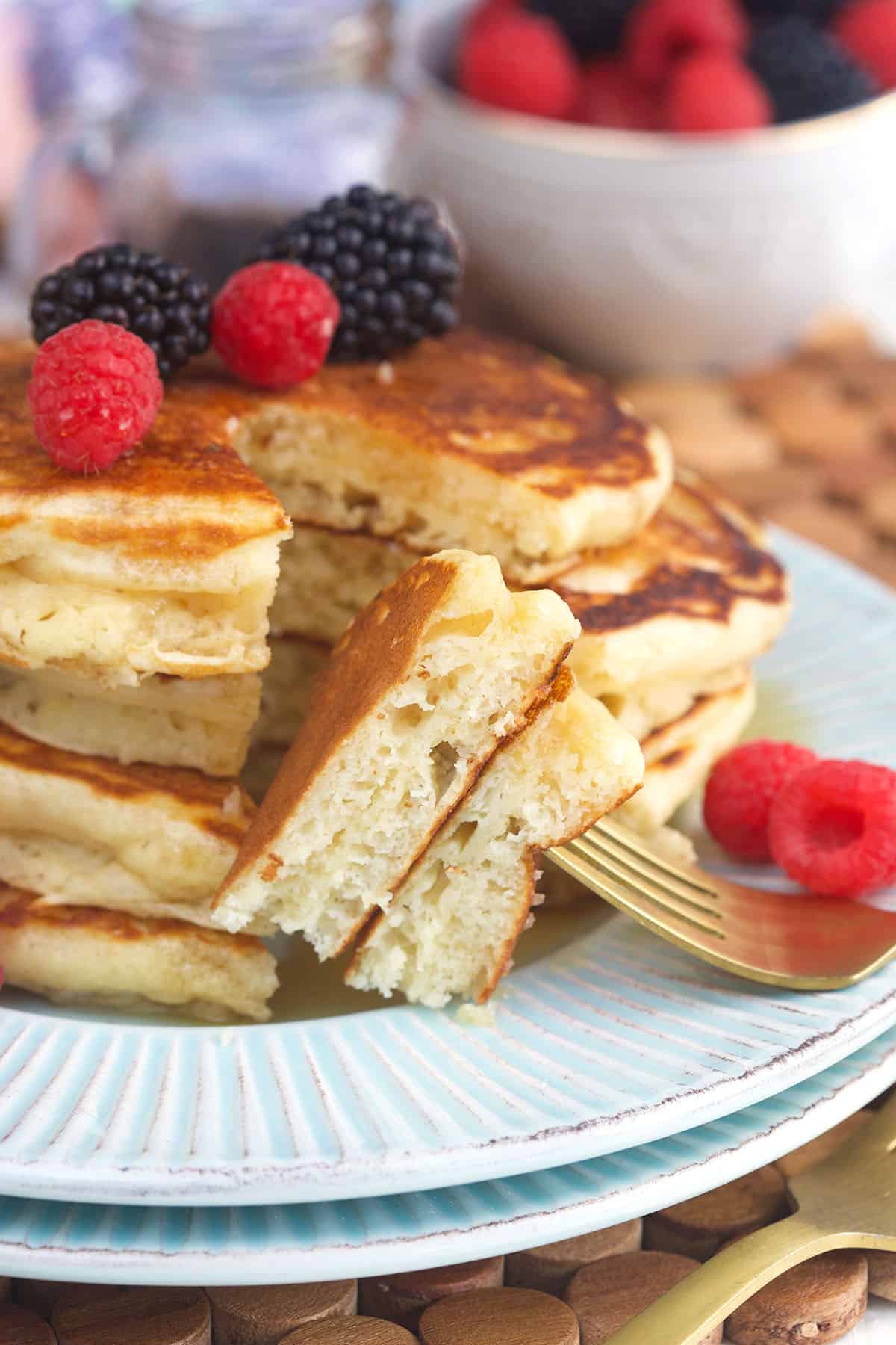 A bite of pancakes has been removed from the stack. 